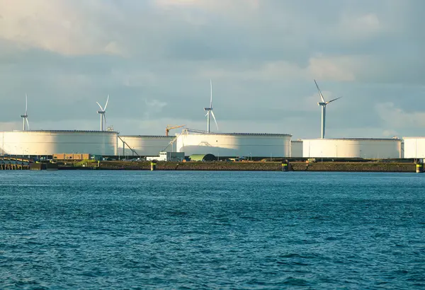 Rotterdam, Hollanda - 22 Kasım 2021: Yeşil ve fosil enerji, rüzgar türbinleri ve fosil yakıtların bir kombinasyonu