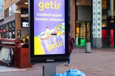 The Hague, Netherlands - January 03 2022: an advertisement screen in the shopping street for a fast grocery delivery service