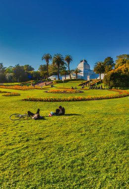 San Francisco, ABD - 27 Şubat 2013: Çimlerin üzerinde uzanmak Golden Gate Park 'ta çiçek konservatuarının yanında dinlenmek.
