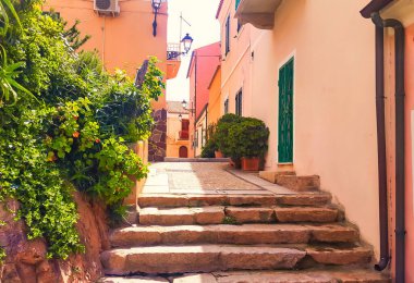La Maddalena, İtalya - 4 Nisan 2016: Sardunya adasındaki bir köyde tarihi İtalyan evleri arasında adımları olan küçük, huzurlu bir ara sokak