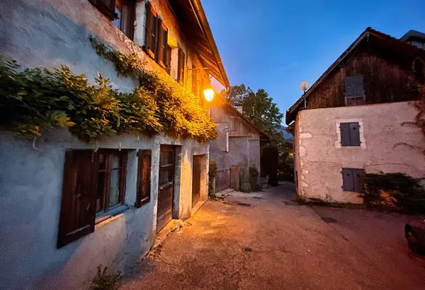 stock image Menthon saint Bernard, France - September 13 2021 : an outside street lantern is shining in the evening in a small historic french village