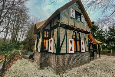 Den Haag, Hollanda - 20 Aralık 2021: Kırsalda panjurları olan küçük tarihi bir peri masalı evi