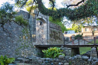 Colonia del sacramento, uruguay - 2 Kasım 2022: UNESCO dünya mirası kolonisinin Barrio tarihindeki San Miguel Kalesi 'nin asma köprüsündeki insanlar