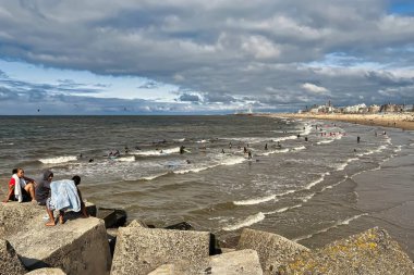 Den Haag, Hollanda - 25 Ağustos 2021: Scheveningen Denizi 'nde sörf dersleri alan birçok genç ve izleyen diğer insanlar