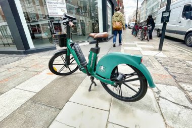 Londra, Birleşik Krallık - 07 Mart 2022: Bir kamu paylaşım sisteminin yeşil elektrikli bisikleti kaldırımın ortasına park edilmiş