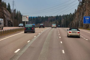 Oslo, Norveç - 25 Nisan 2012: Bir dağ öfkesinin içinden geçen Oslo yakınlarındaki bir otoyol manzarası. Arabalar ve trafik işaretleriyle dolu