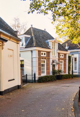 Wassenaar, Hollanda - Kasım 06 2020: Dar bir köy yolu boyunca küçük tarihi Hollandalı evler görüldü