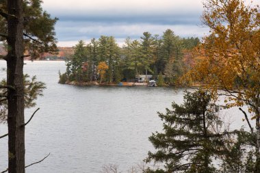 kawartha lakes, canada - 20 October 2022: a cabin on the shore of a small lake in the kawartha lakes region in fall colors