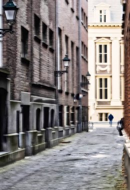 Lahey, Hollanda - 22 Ekim 2020: tarihi bir Hollanda şehrinde her iki tarafında binalar, sokak fenerleri, arka giriş kapısı ve uzakta yürüyen bir kişi olan karanlık arka sokak.