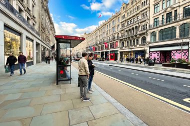 Londra, Birleşik Krallık - 6 Mart 2022: İnsanlar Viktorya dönemi binaları ve tipik İngiliz otobüsleriyle ünlü kral naibi caddesinde alışveriş yapıyorlar.