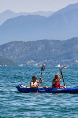 Annecy, Fransa - 21 Ağustos 2008: iki kişi doğa ve dağların muhteşem manzarası ile Annecy Dağı 'nda kano ya da kayıkla geziyor.