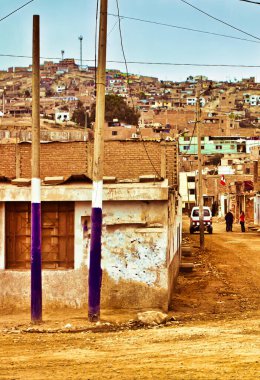Lima, Peru - 13 Ağustos 2010: Peru 'da bir gecekondu mahallesinde toprak yolda iki kişi yürüyor