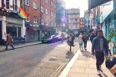 Londra, Birleşik Krallık - 6 Mart 2022: SOHO mahallesinde kaldırımda birçok modern insan ile cadde meşgul