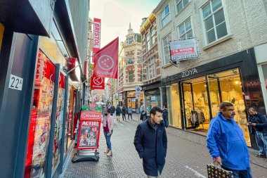 Lahey, Hollanda - 16 Aralık 2021: Kentin tarihi bir alışveriş caddesinde birçok kişi alışveriş çantalarıyla yürüyor
