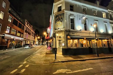 Londra, Birleşik Krallık - 6 Mart 2022: kulüplerin gece hayatı restoranı ve barları ile canlı bir Soho sokağı.