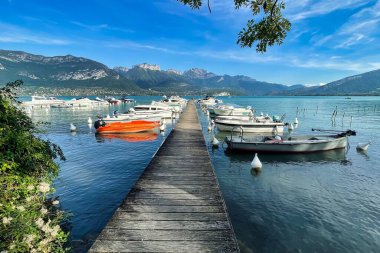 Annecy, Fransa - Ekim 01 2021: Kristal açık alp gölü boyunca lüks tekneleri olan bir rıhtım veya iskele.