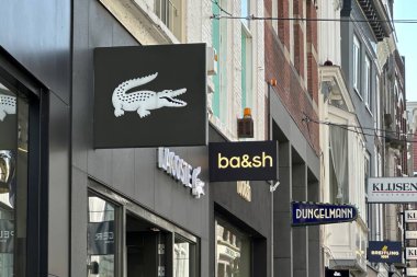 Hague, Hollanda - 02 Mayıs 2024: Fransız perakende zinciri Lacoste 'nin ön cephesindeki giriş ve logo