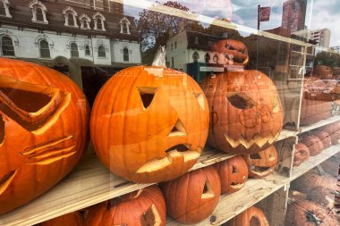 toronto, canada - 25 October 2022:carved out faces on orange pumpkins on sale and displayed in a shop