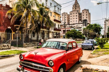 Havana, Küba - Temmuz 06 2018: Eski Amerikan arabaları caddenin her yerinde bulunacak. Arka tarafta eski bir Amerikan binası var..