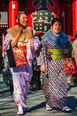 Tokyo, Japonya - 26 Kasım 2012: Geleneksel Japon elbiseli kadınlar Tokyo 'nun en yoğun manzaralarından biri olan Asakusa' daki Senso ji tapınağında hafta sonu kalabalığında yürüyorlar