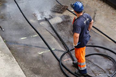 Menthon Saint Bernard, Fransa - 09 Eylül 2021: profesyonel bir işçi kanalizasyon borusunu temizlerken pompalı araba ve yüksek basınçlı hortumla meşgul