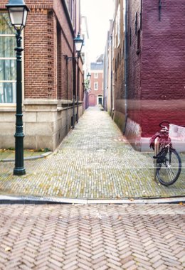 Lahey, Hollanda - 22 Ekim 2020: binaların, sokak fenerlerinin ve gizemlerin ön cephelerinin bulunduğu tarihi eski bir ara sokağa tipik bir Hollanda manzarası