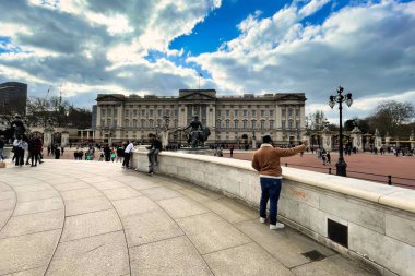 Londra, Birleşik Krallık - 6 Mart 2022: Kraliçe Victoria Anıtı 'nda ve Buckingham Sarayı' nın alışveriş merkezi tarafında turistler