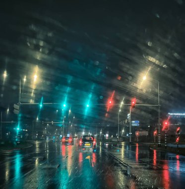 The Hague, netherlands - March 31 2022: reflections of traffic lights and back lights of cars on a wet snowy road at night