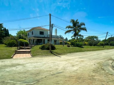 nueva helvecia, uruguay - November 1 2022: spanish colonial building style house on the countryside with palm tree clipart