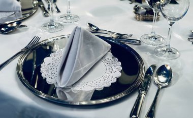 Çatal bıçak takımı, keten ve tabak takımları olan bir restoranda iyi hazırlanmış özel bir masa.