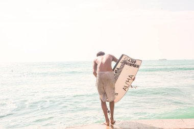 Honolulu, ABD, Aralık 06 2012: Aloha sörf tahtası ile Hawaii sörfü Waikiki sahilinde suya atlıyor