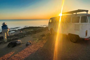 colonia del sacramento, uruguay - Kasım 2 2022: Deniz veya okyanus batımı manzaralı bir Volkswagen minibüsü veya otobüs