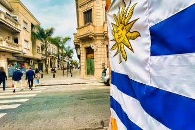 Montevideo, uruguay - 30 Ekim 2022: Uruguay bayrağı Ciudad Vija 'da asılı ve insanlar ana alışveriş caddesinde yürüyor