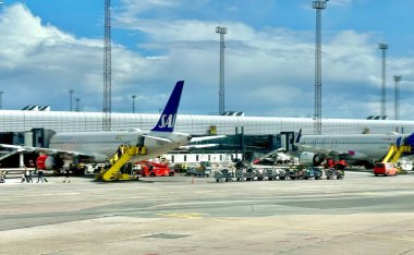 Kopenhag, Danimarka - 26 Temmuz 2023: SAS uçakları şehrin modern havaalanı terminalinin kapısına park edildi