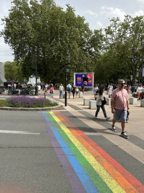 Ek bina, Fransa - 8 Haziran 2024: İnsanlar gökkuşağı renkleriyle yaya geçidinde karşıdan karşıya geçerken görülüyor