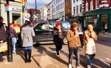 Londra, Birleşik Krallık - 6 Mart 2022: SOHO mahallesinde kaldırımda birçok modern insan ile cadde meşgul