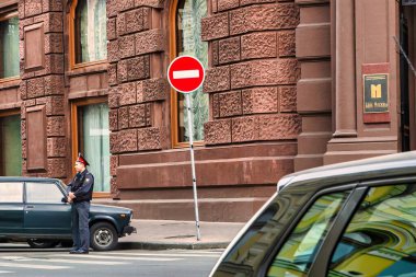 Moskova, Rusya - 11 Eylül 2010: Bir polis memuru banka binasının önünde Sovyet arabasının yanında nöbet tutuyor.