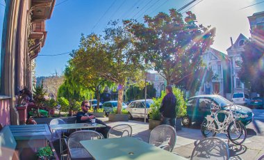 San Francisco, ABD - 27 Şubat 2013: İnsanlar güneşli bir günde San Francisco 'nun canlı bir mahallesinde yeşil ve klasik mimari ile çevrili olarak rahatlar..