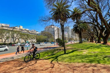 buenos aires, Argentina - 27 October 2022: cyclist in small park in the city with palm trees