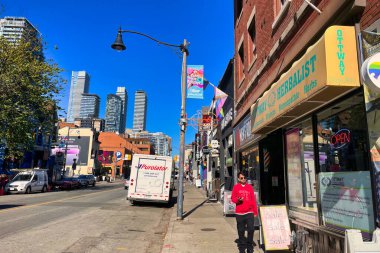 toronto, canada - 24 October 2022: a person walking on the sidewalk of gay church street with bars restaurants shops and gay or lgbtq clubs