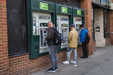 Toronto, Kanada - 25 Ekim 2022: İnsanlar bankanın önünde ATM 'den para çekiyorlar.