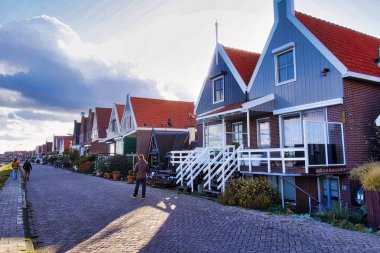 Volendam, Hollanda - 08 Ekim 2022: su boyunca kırsal alanda bulunan tipik Hollanda renkli ahşap evler dizisi