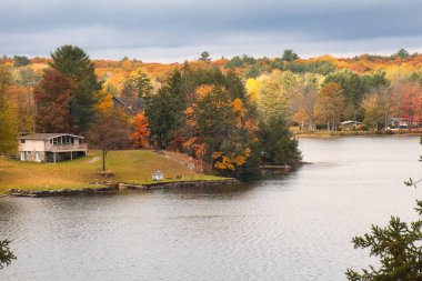 kawartha lakes, canada - 20 October 2022: a cabin on the shore of a small lake in the kawartha lakes region in fall colors