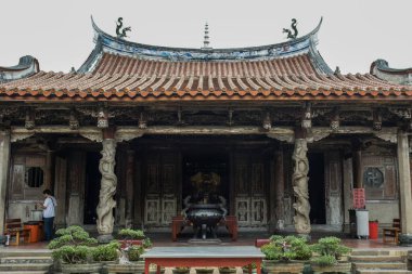 Lukang, Tayvan - 06 Aralık 2016: Ziyaretçiler, bulutlu bir günde Taichung 'da karmaşık oymalar ve geleneksel mimari eserlerle çevrili tarihi bir tapınağı keşfediyorlar.