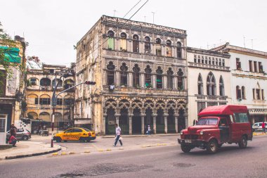 Havana, Küba - Temmuz 06 2018: Havana 'daki çarpıcı koloni mimarisinin yanından geçen renkli vintage araçlar zengin tarih ve kültürleri gözler önüne seriyor.
