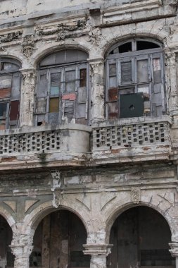 Havana, Küba - Temmuz 06 2018: Havana 'daki eski yıpranmış bir bina mimari olarak solmuş ve şehrin zengin tarihini yansıtan kısmen tahtalı pencereler.