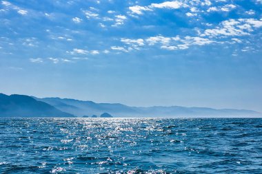 Puerto Vallarta, Meksika - Şubat 05 2017: Okyanus açık bir günde Puerto Vallarta 'daki uzak dağlara doğru uzanırken güneş ışığı dalgaların üzerinde parıldıyor.