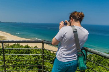 Sokcho, Güney Kore - Haziran 09 2015: Bir gezgin güneşli bir günde güzel manzarayı çekerken çarpıcı bir kıyı manzarasının keyfini çıkarıyor.