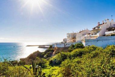 Albufeira, Portekiz - 18 Ocak 2016: Deniz kenarındaki parlak güneş ve resimli beyaz binalarla Albufeira kıyı şeridinin çarpıcı manzarası.