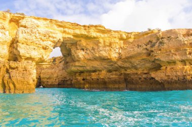 Albufeira, Portekiz - 20 Ocak 2016: Parlak turkuaz sular güneşli bir günde Albufeiras kıyı şeridi boyunca eşsiz kaya oluşumlarını çevrelemektedir..
